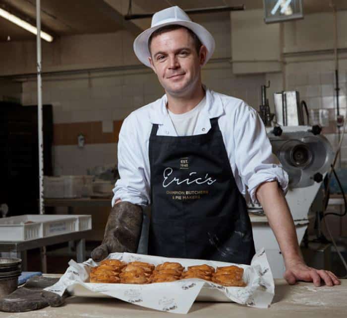 Eric’s pies brand collateral showcasing one of their staff having taken a fresh batch of pies out the oven.